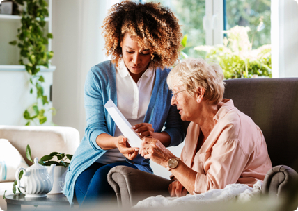 Young woman helping older woman look over documents