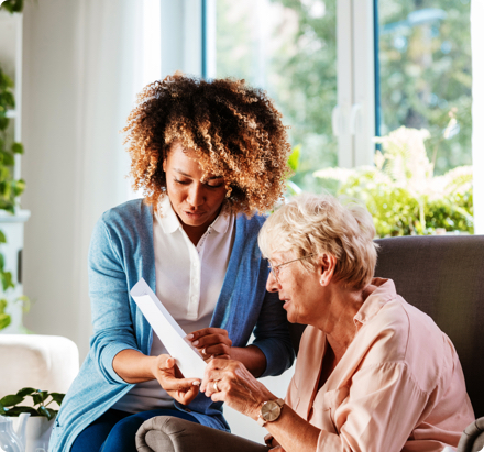 Young woman helping older woman look over documents