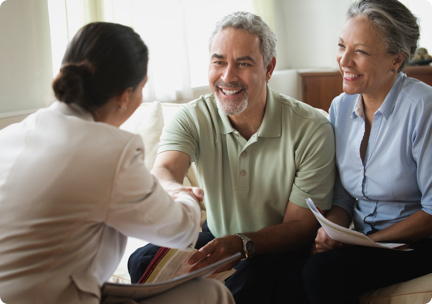 Woman shakes hand with smiling couple